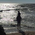 Week-end en Normandie en famille : enfant sur les épaules d'un adulte face à la Manche sur la plage de Pourville-sur-Mer