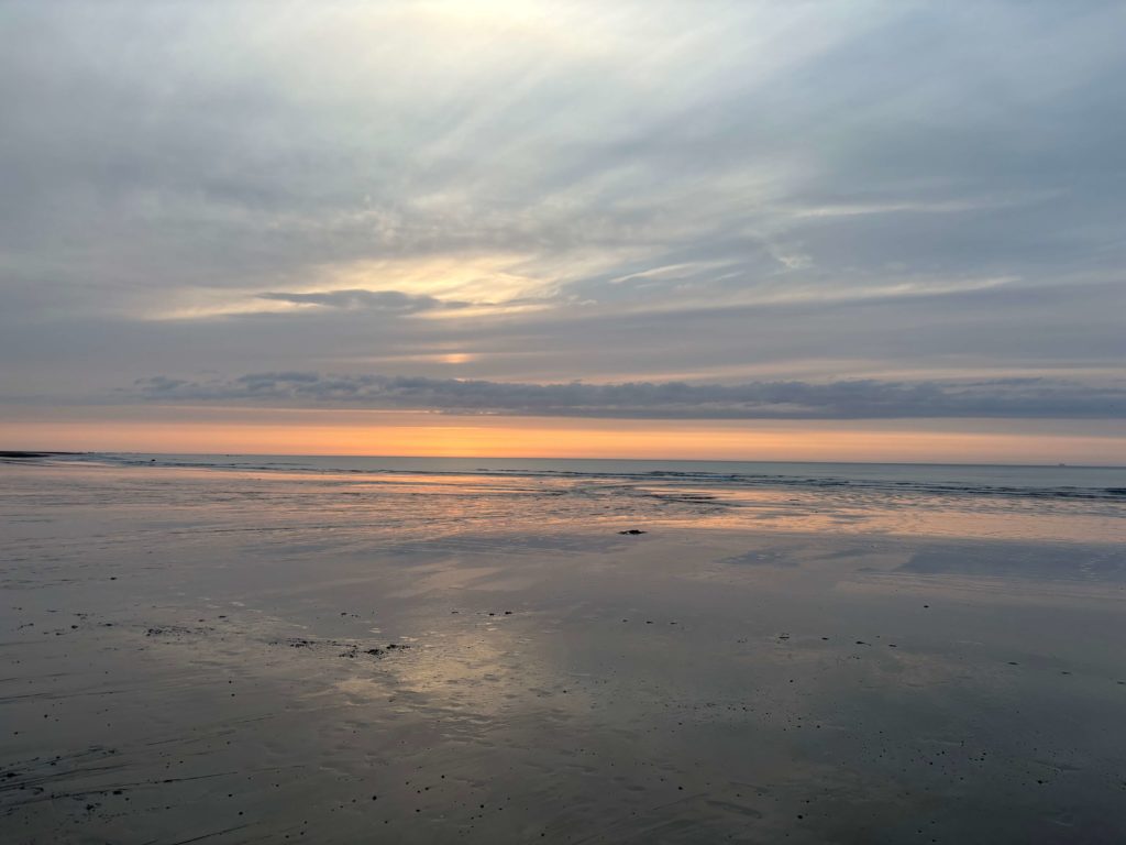 Plage à marée basse avec reflets et coucher de soleil à Pourville-sur-Mer en Normandie