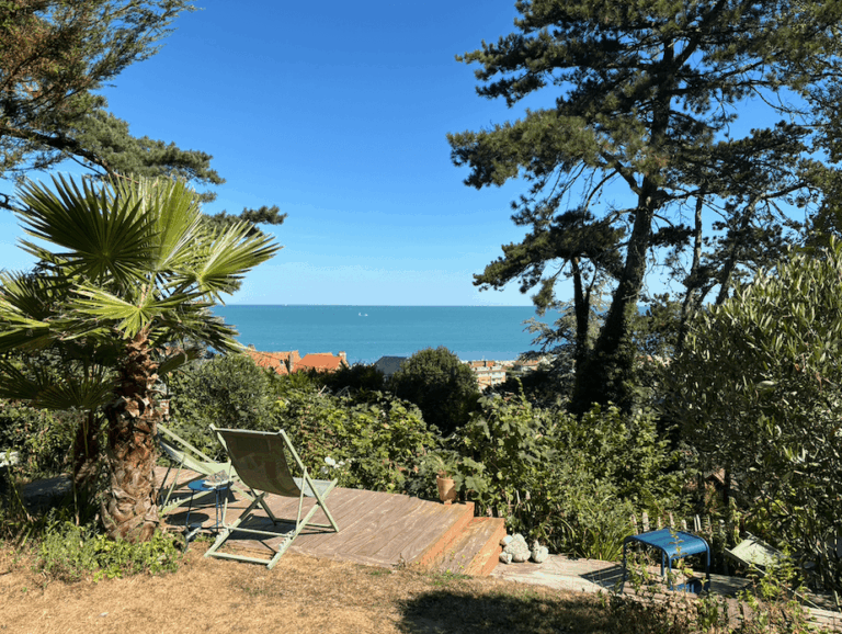 Terrasse en bois et transats dans le jardin exotique du Carré Vue Mer, avec vue sur la mer à Pourville-sur-Mer