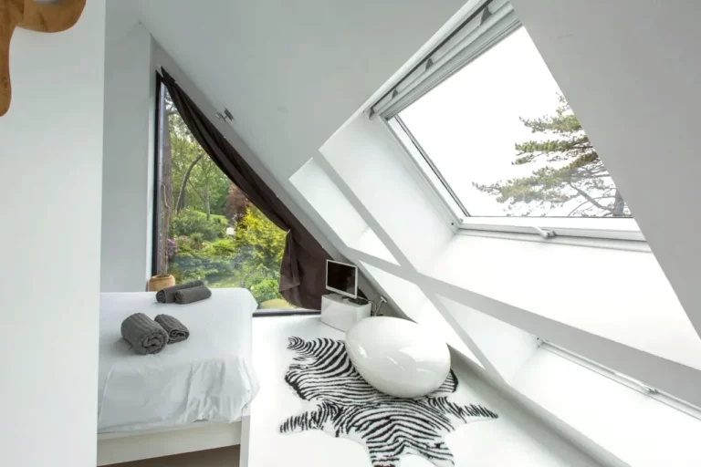 Zimmer Ouest unter dem Dach mit offenem Dachfenster, Zebrateppich und Dreiecksfenster