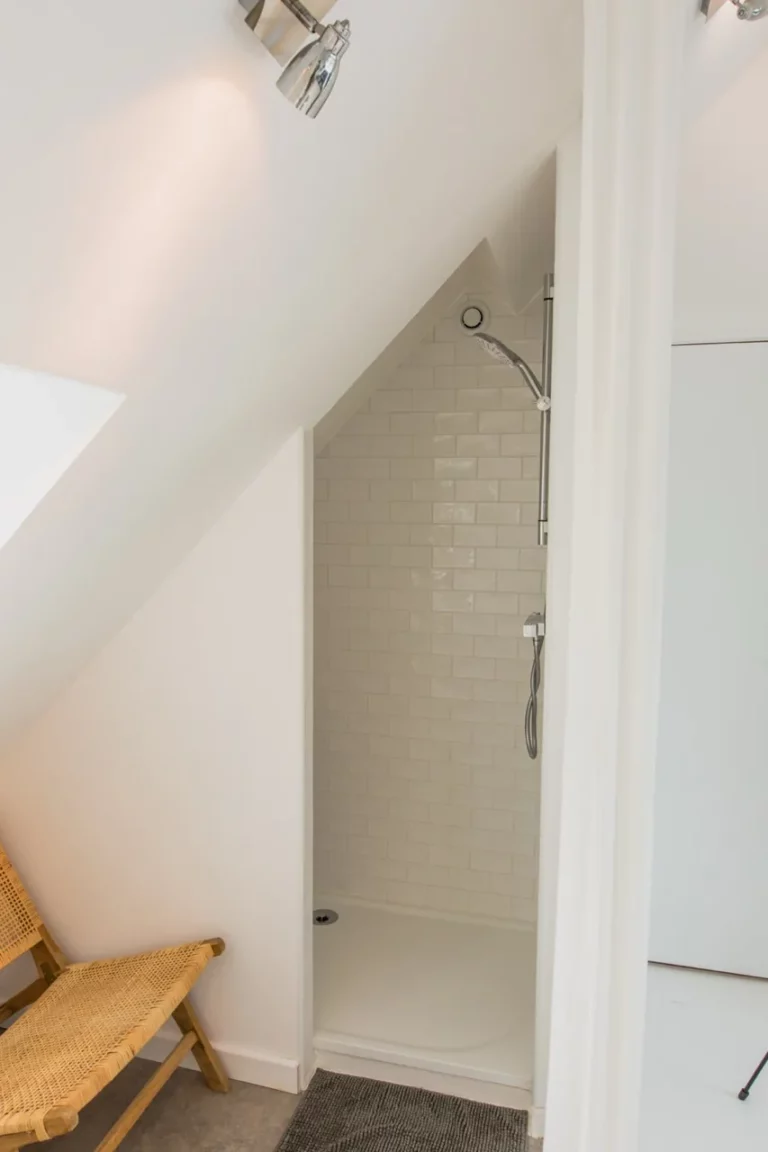 Dusche unter der Dachschräge im Zimmer Est, weiße Metrofliesen und Vorhang