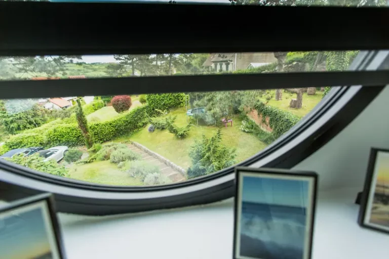 Rundes Fenster des Zimmers Est mit Blick in den Garten