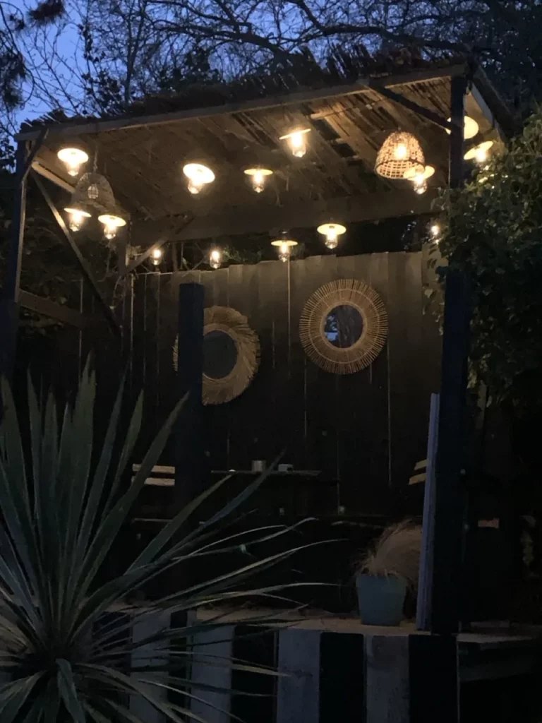 Pergola avec guirlande lumineuse la nuit dans le jardin de la villa à Pourville