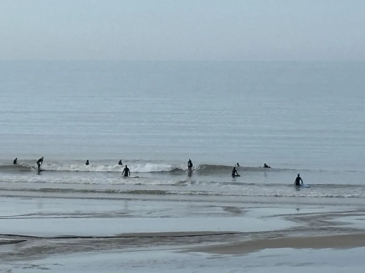 Surfeurs à la plage de Pourville-sur-Mer à marée basse en Normandie