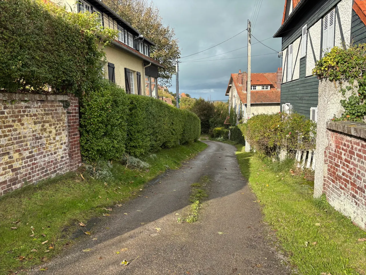 Ruelle vers la plage à Pourville Ruelle entre villas normandes et murs de brique sur le chemin de la plage de Pourville à pied