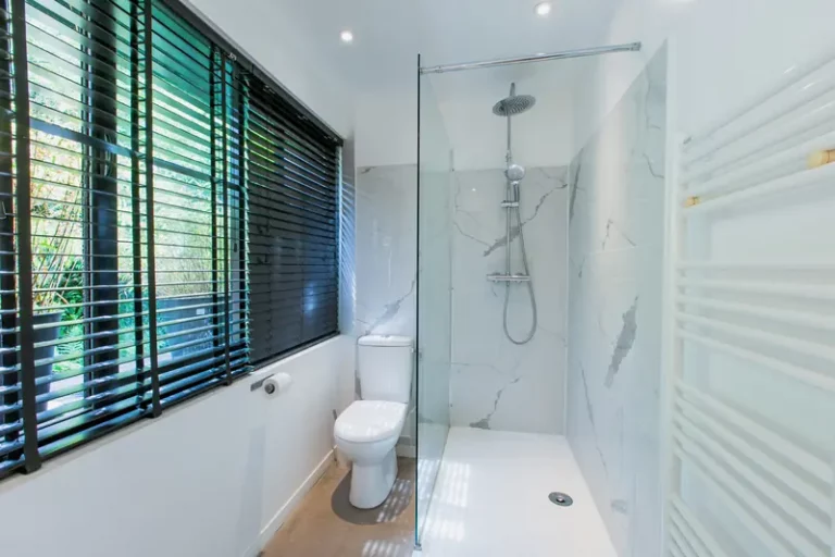 Duschbad des Zimmers Albion im Erdgeschoss, ebenerdige Dusche aus weißem Marmor und WC